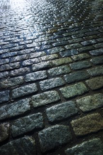 USA, New York, New York City, close up of cobblestone street at night.
