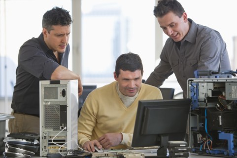 IT Professionals repairing computer in office.