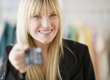 Young woman holding credit card. Photo : Jamie Grill Photography