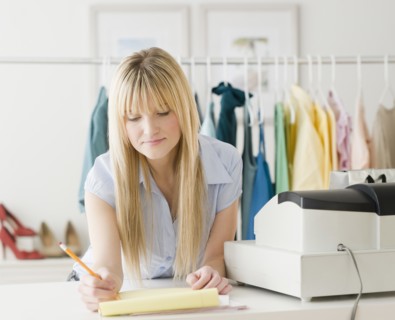 Young businesswoman doing paperwork. Photo : Jamie Grill Photography