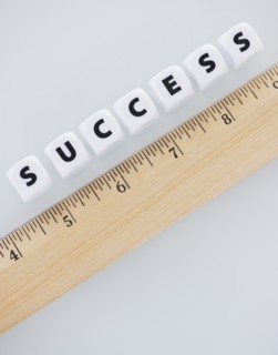 Studio shot of ruler and dice spelling out success. Photo : Daniel Grill