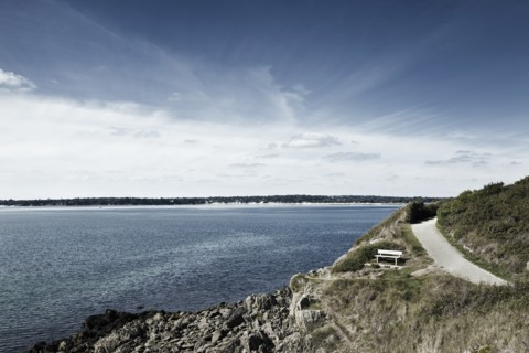 France, Brittany, Finistere Department, Bench, coastline and ocean. Photo: Jon Boyes