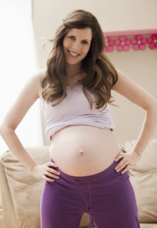 Young pregnant woman showing belly. Photo: Mike Kemp
