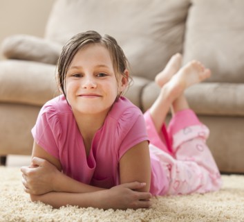 Portrait of girl (10-11) lying on floor. Photo : Mike Kemp