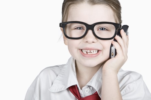 Studio portrait of girl (6-7) dressed-up as businesswoman. Photo : Justin Paget