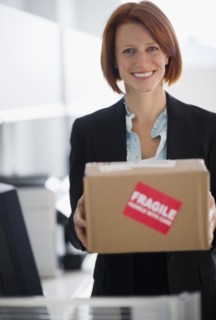 Businesswoman holding box. Photo : Jamie Grill Photography