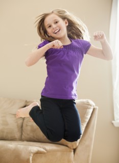 Portrait of girl (8-9) jumping. Photo : Mike Kemp