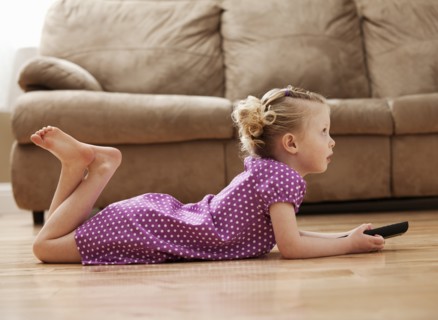 Girl (2-3) lying on floor, watching TV. Photo: Mike Kemp