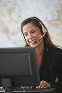 Female customer service representative with headset working on computer.