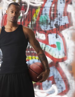 USA, Utah, Salt Lake City, portrait of basketball player in front of graffiti. Photo : Mike Kemp