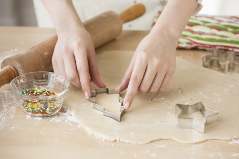 Woman preparing biscuits with pastry cutter.