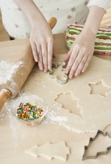 Woman preparing biscuits with pastry cutter.