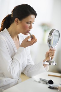 Woman applying lipstick.