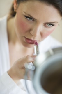 Woman applying lipstick.