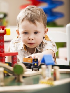 Boy (2-3) playing with toy train. Photo: Mike Kemp