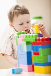 Boy (2-3) playing with colorful blocks. Photo: Mike Kemp