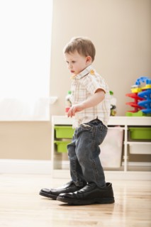 Boy (2-3) walking in dad's shoes. Photo: Mike Kemp
