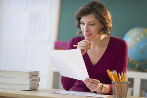 Portrait of teacher at desk in classroom.