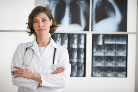 Portrait of doctor with x-ray images in background.