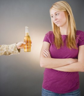 Young woman being offered beer. Photo : Jamie Grill Photography