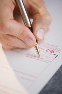 Hand filling tax form. Photo : Jamie Grill Photography