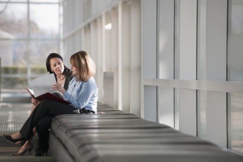 Businesswomen talking in corridor. Photo : Mark Edward Atkinson