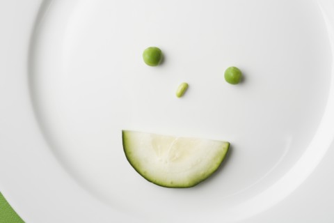 Anthropomorphic face made up from green peas and cucumber slice. Photo : Kristin Lee
