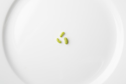 Peas on white plate forming recycling symbol. Photo : Kristin Lee
