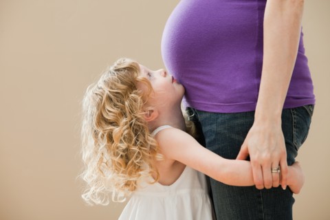 Girl (2-3) and pregnant mother holding hands. Photo: Mike Kemp