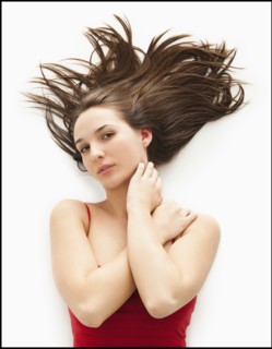 Studio portrait of young woman with windswept hair. Photo : Mike Kemp