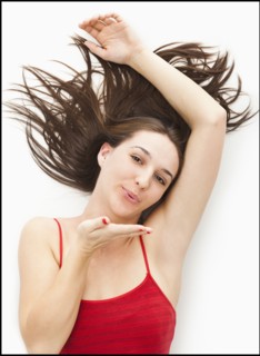 Studio portrait of young woman blowing a kiss. Photo: Mike Kemp