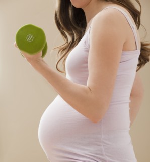 Young pregnant woman excercising with dumbbells. Photo: Mike Kemp