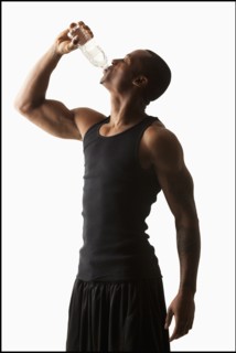 Studio shot of man drinking water from bottle. Photo : Mike Kemp
