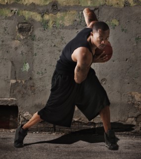 USA, Utah, Salt Lake City, man playing basketball in front of wall. Photo : Mike Kemp