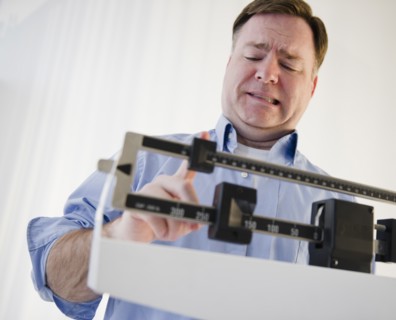 Man on weight scales. Photo : Jamie Grill Photography