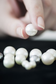 Woman holding pearl.