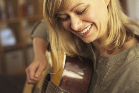 Woman playing guitar. Photo : DreamPictures