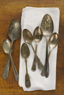 Close up of rusty silver spoons and napkin.