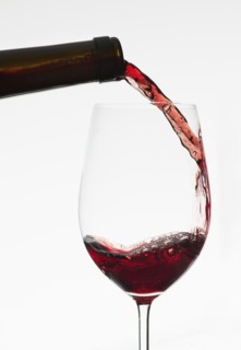 Close up of red wine being poured into wine glass.
