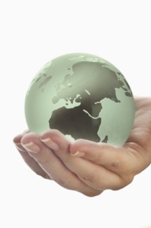 Studio shot of woman holding glass globe model.