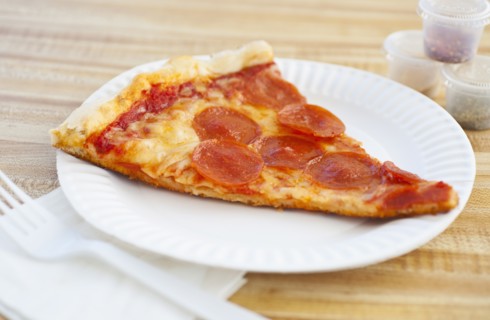 Slice of pepperoni pizza on plate.