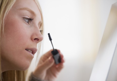 Young woman applying mascara. Photo : Jamie Grill Photography