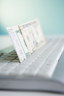 Studio shot of banknotes in computer keyboard. Photo : Jamie Grill Photography