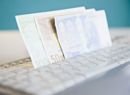 Studio shot of banknotes in computer keyboard. Photo : Jamie Grill Photography