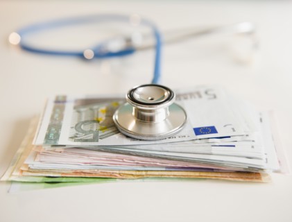 Studio shot of stethoscope on banknotes. Photo : Jamie Grill Photography