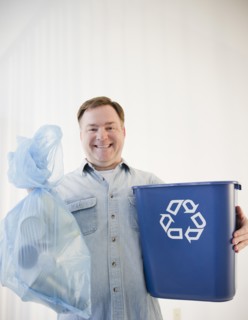 Man holding bag and recycling bin. Photo : Jamie Grill Photography