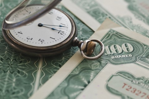 Close up of pocket watch and shares.