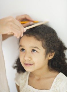 Mother measuring daughter (6-7).