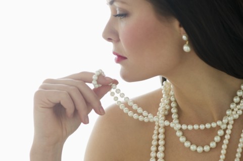 Profile of young woman wearing pearls.