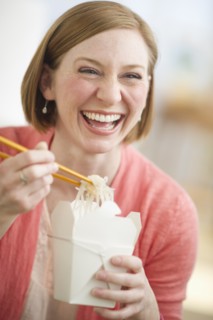 Woman eating Chinese take out food.